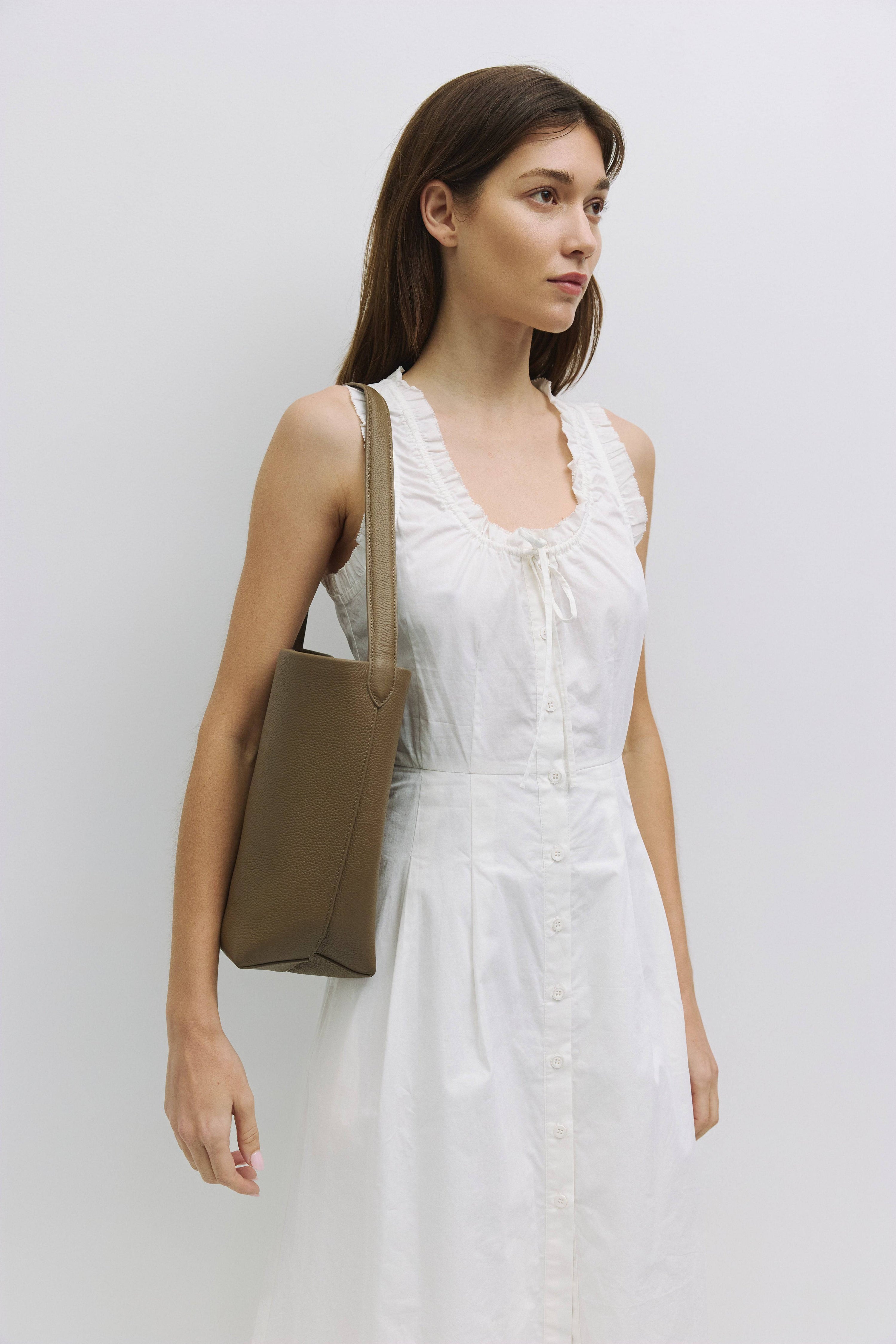 8857782157533, The Elise Tote Bag, Bags, Mod Ref | Common Market, accessories,bag,bags,cf-color-khaki,cf-color-white,cf-vendor-mod-ref-common-market,dark brown,modrefcommonmarket,Oversized,purse, Information The Elise Tote Bag features a top tie closure and an integrated leather shoulder strap for a simple yet functional design. The removable inner lining offers extra versatility, allowing you to easily clean or switch up the interior as needed. Details 100% Cowhide Top Tie Closure Leather Shoulder Strap Re