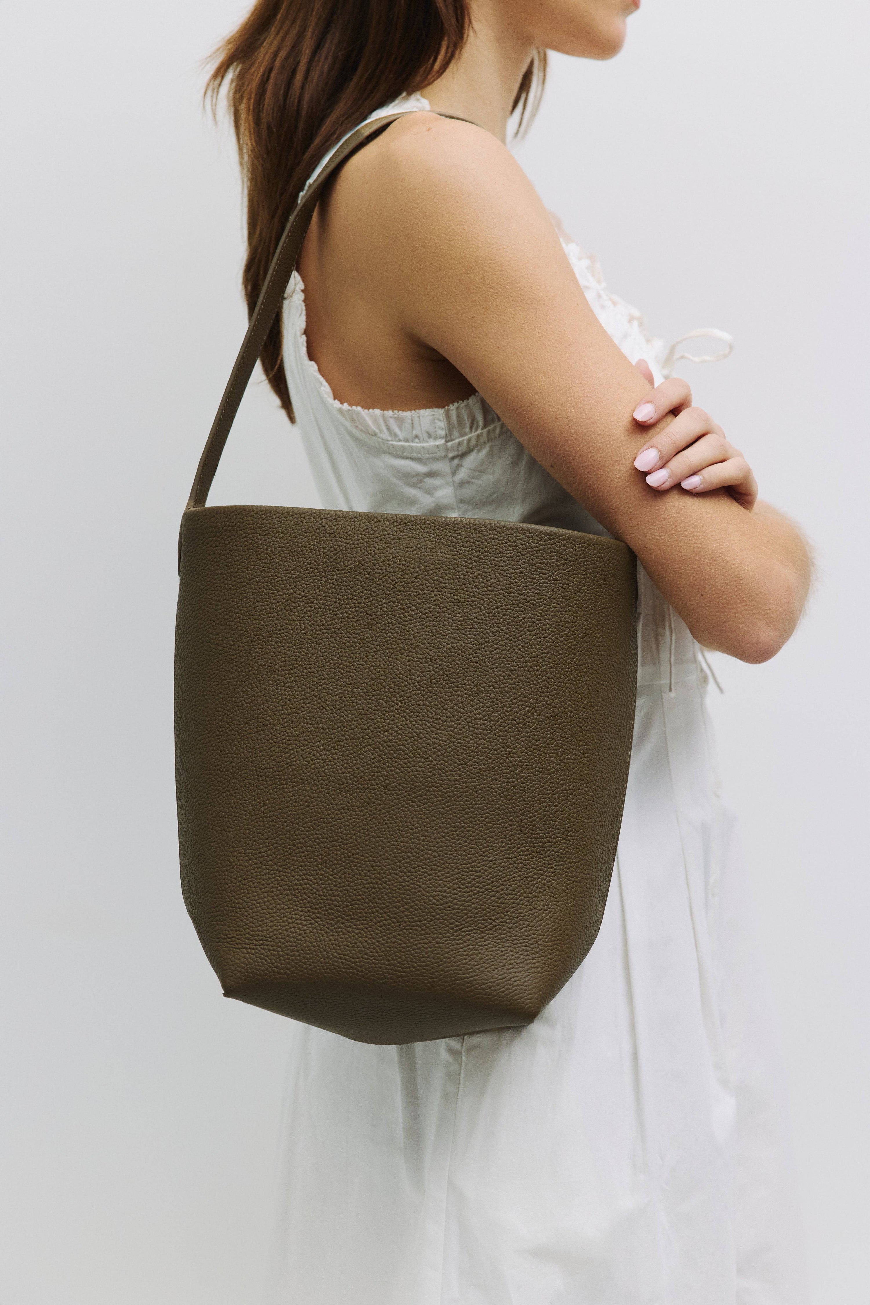 8857782157533, The Elise Tote Bag, Bags, Mod Ref | Common Market, accessories,bag,bags,cf-color-khaki,cf-color-white,cf-vendor-mod-ref-common-market,dark brown,modrefcommonmarket,Oversized,purse, Information The Elise Tote Bag features a top tie closure and an integrated leather shoulder strap for a simple yet functional design. The removable inner lining offers extra versatility, allowing you to easily clean or switch up the interior as needed. Details 100% Cowhide Top Tie Closure Leather Shoulder Strap Re