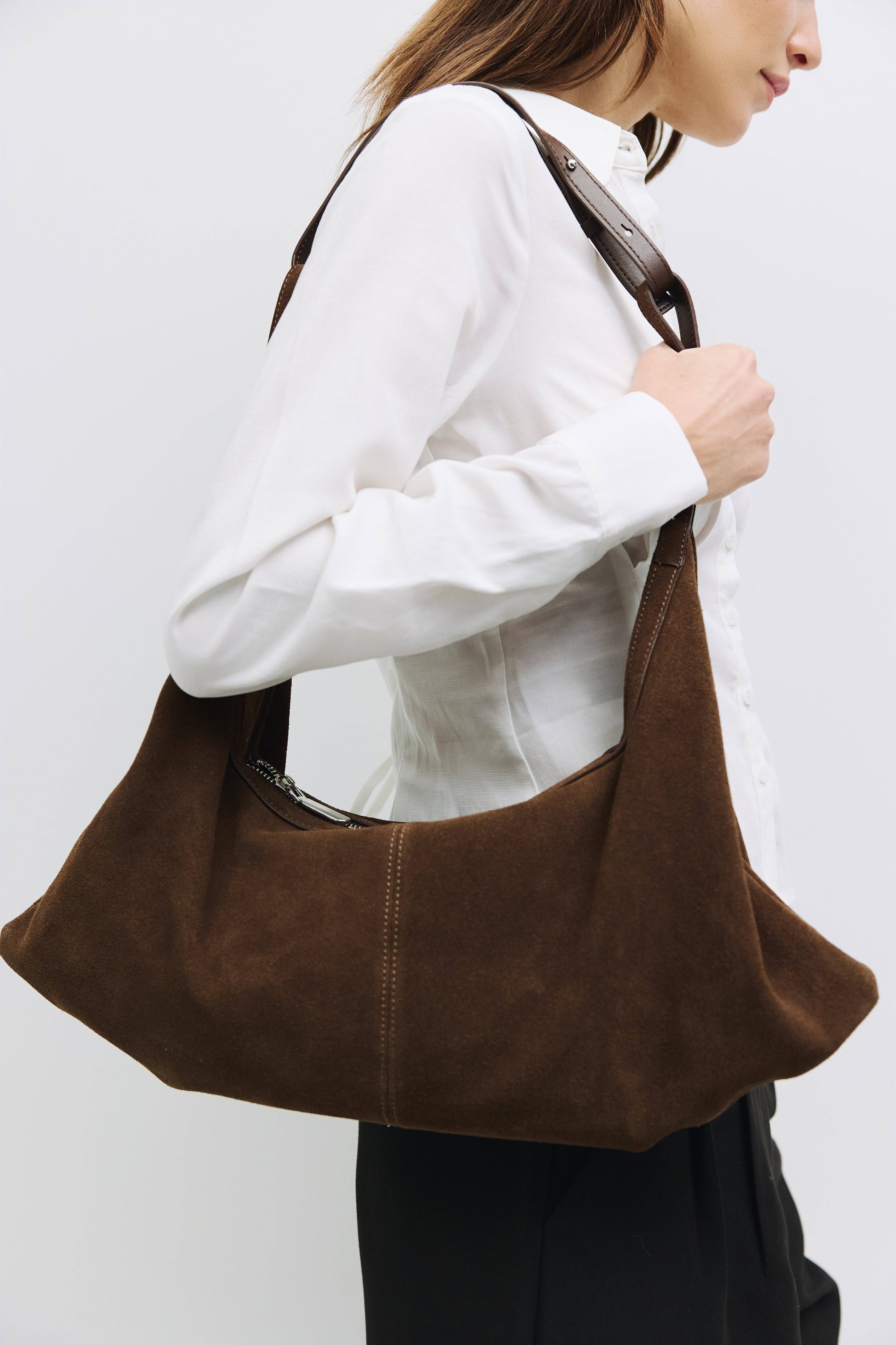 8857769345245, The Erin Shoulder Bag, Bags, Mod Ref | Common Market, accessories,bag,bags,cf-color-khaki,cf-color-white,cf-vendor-mod-ref-common-market,dark brown,modrefcommonmarket,Oversized,purse, Information The Erin Shoulder Bag features a relaxed, slouchy shape with a center seam detail and is crafted from suede leather for a modern look. The zip closure, inner pocket console, and detachable top strap offer both practicality and versatility for everyday use. Details 100% Cowhide Slouchy Shape Suede Lea
