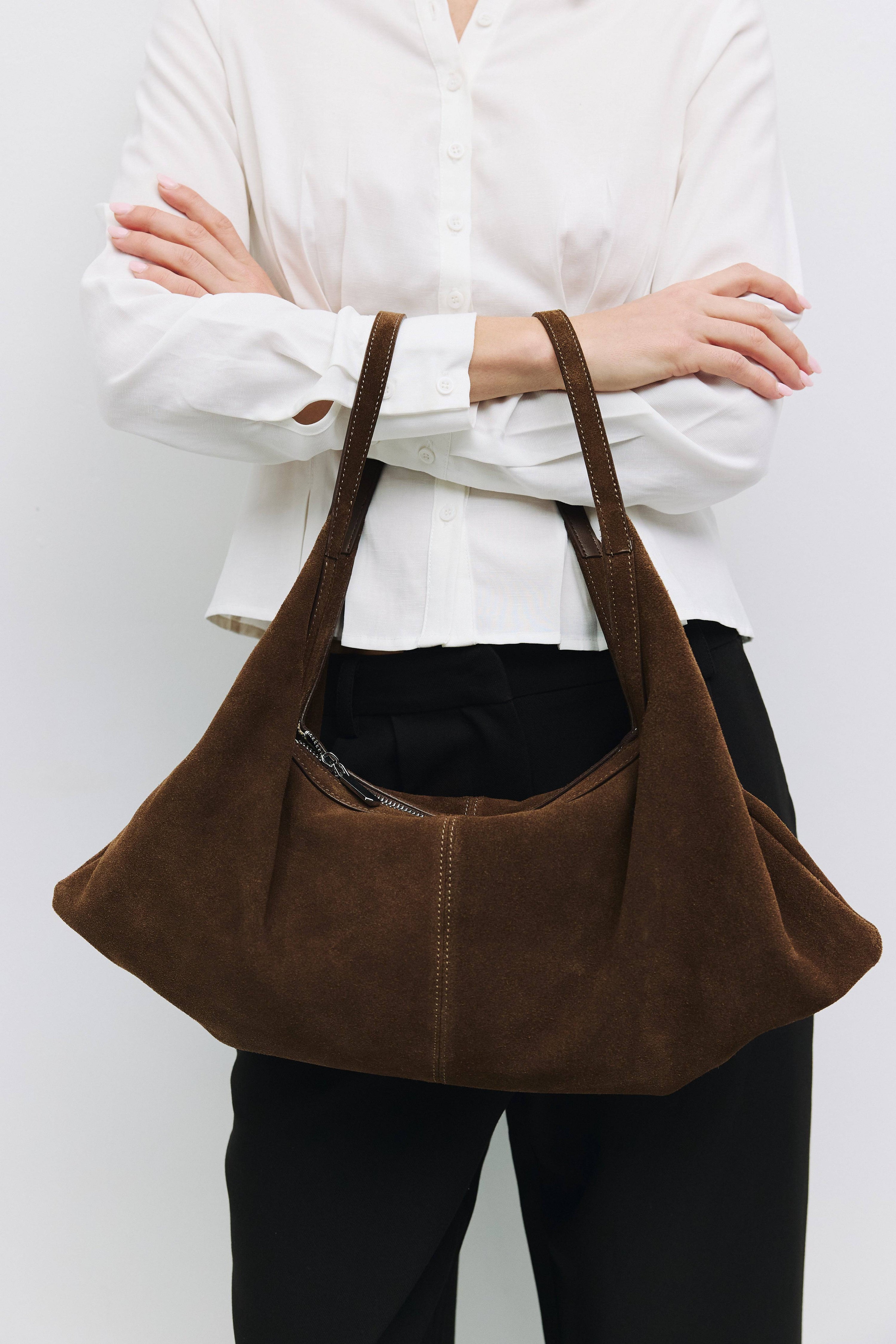 8857769345245, The Erin Shoulder Bag, Bags, Mod Ref | Common Market, accessories,bag,bags,cf-color-khaki,cf-color-white,cf-vendor-mod-ref-common-market,dark brown,modrefcommonmarket,Oversized,purse, Information The Erin Shoulder Bag features a relaxed, slouchy shape with a center seam detail and is crafted from suede leather for a modern look. The zip closure, inner pocket console, and detachable top strap offer both practicality and versatility for everyday use. Details 100% Cowhide Slouchy Shape Suede Lea