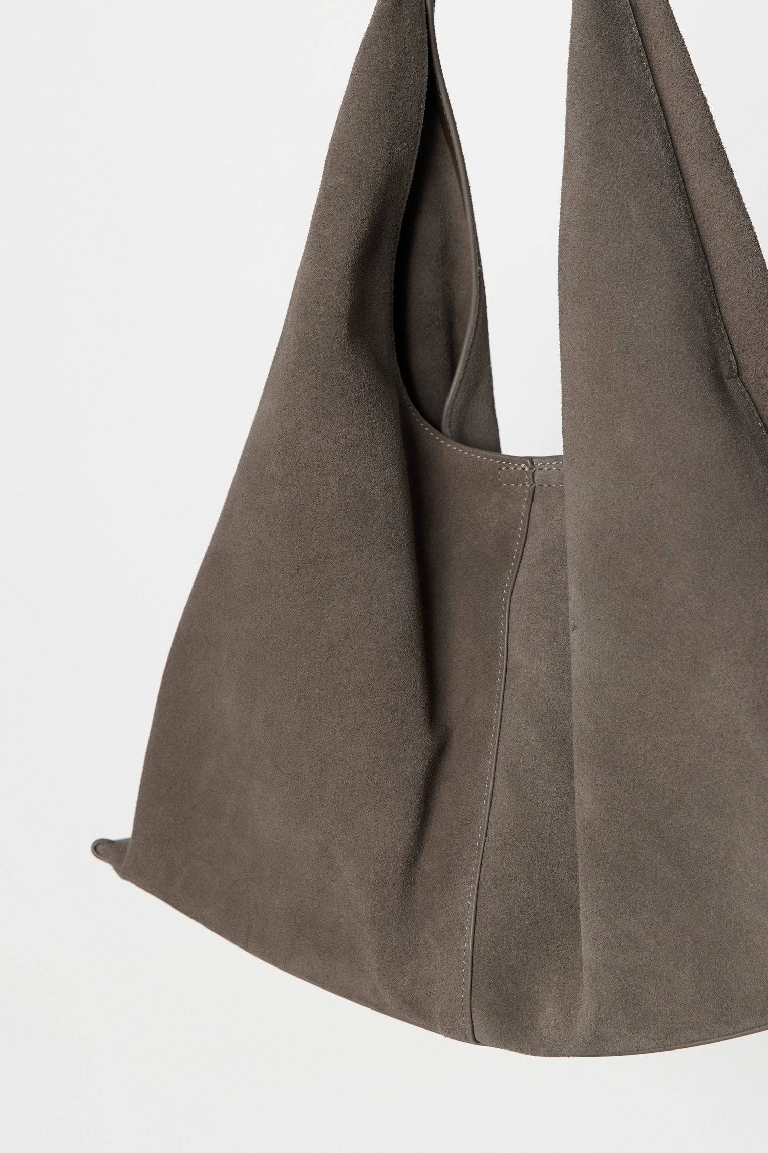 8857791201501, The Kaila Bindle Bag, Bags, Mod Ref | Common Market, accessories,bag,bags,cf-color-khaki,cf-color-white,cf-vendor-mod-ref-common-market,dark brown,modrefcommonmarket,Oversized,purse, Information The Kaila Bindle Bag features a slouchy shape with a front seam detail offering a touch of effortless style. Crafted with an integrated suede strap, durable patent leather bottom support, and a magnetic snap closure, it combines practicality with a laid-back, contemporary feel. Details 100% Cowhide Fr