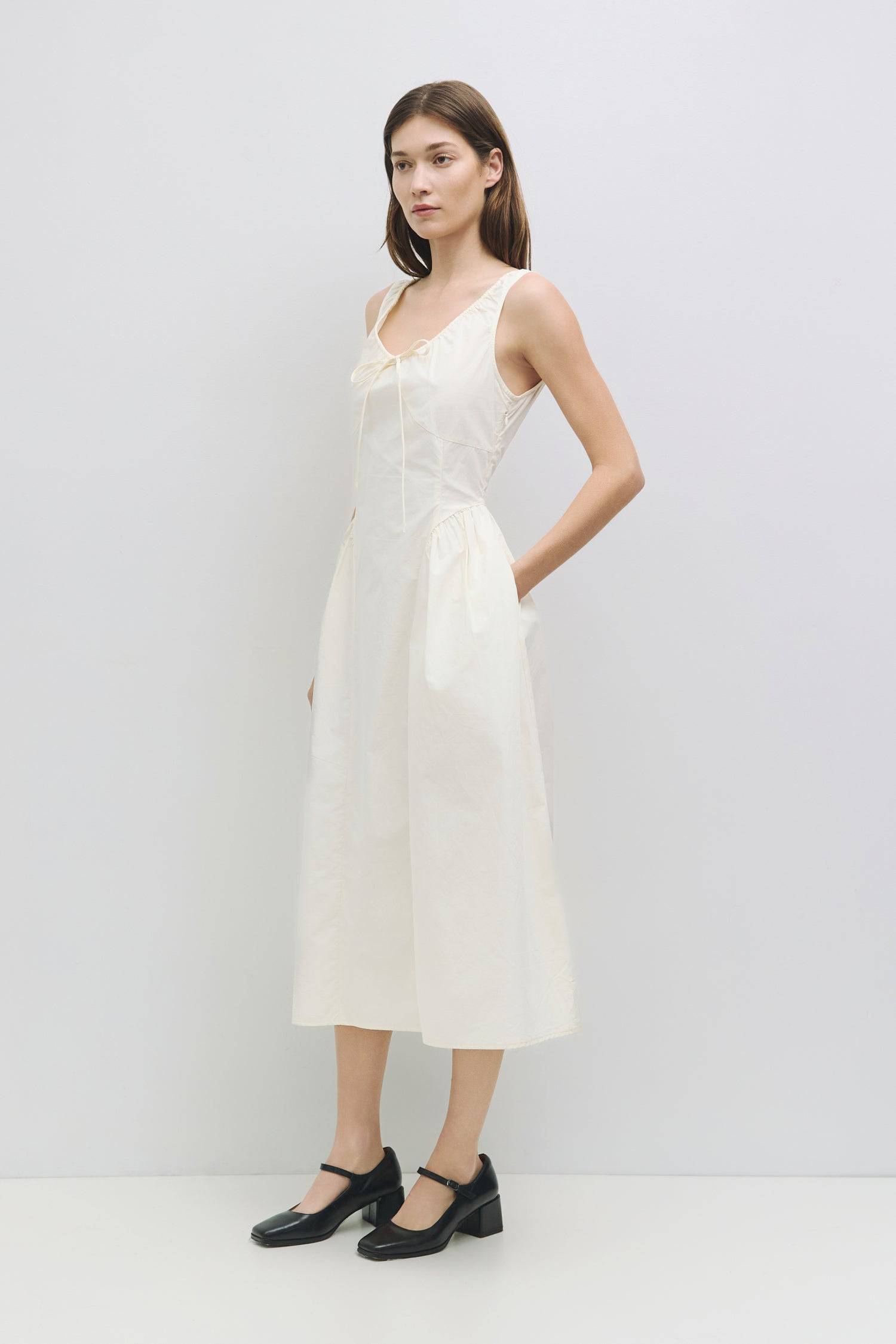 8911662874845, The Anika Dress, Dress, All Row, Casual,cf-color-white,cf-size-l,cf-size-m,cf-size-s,cf-vendor-mod-ref,Cinched Waist,Comfortable,Cotton,curve skirt,drawstring waist,Dress,dressy,final-sale,finalsale,Long Dress,maxi dress,Mid Length Dress,Midi,Midi Dress,midi length,new,sale,side pockets,Sleeveless,Spring,Summer,voluminous,womens, Information The Anika Dress is a comfortable sleeveless midi dress featuring a gathered neck design and front ties for a personalized fit. With shirring around the n