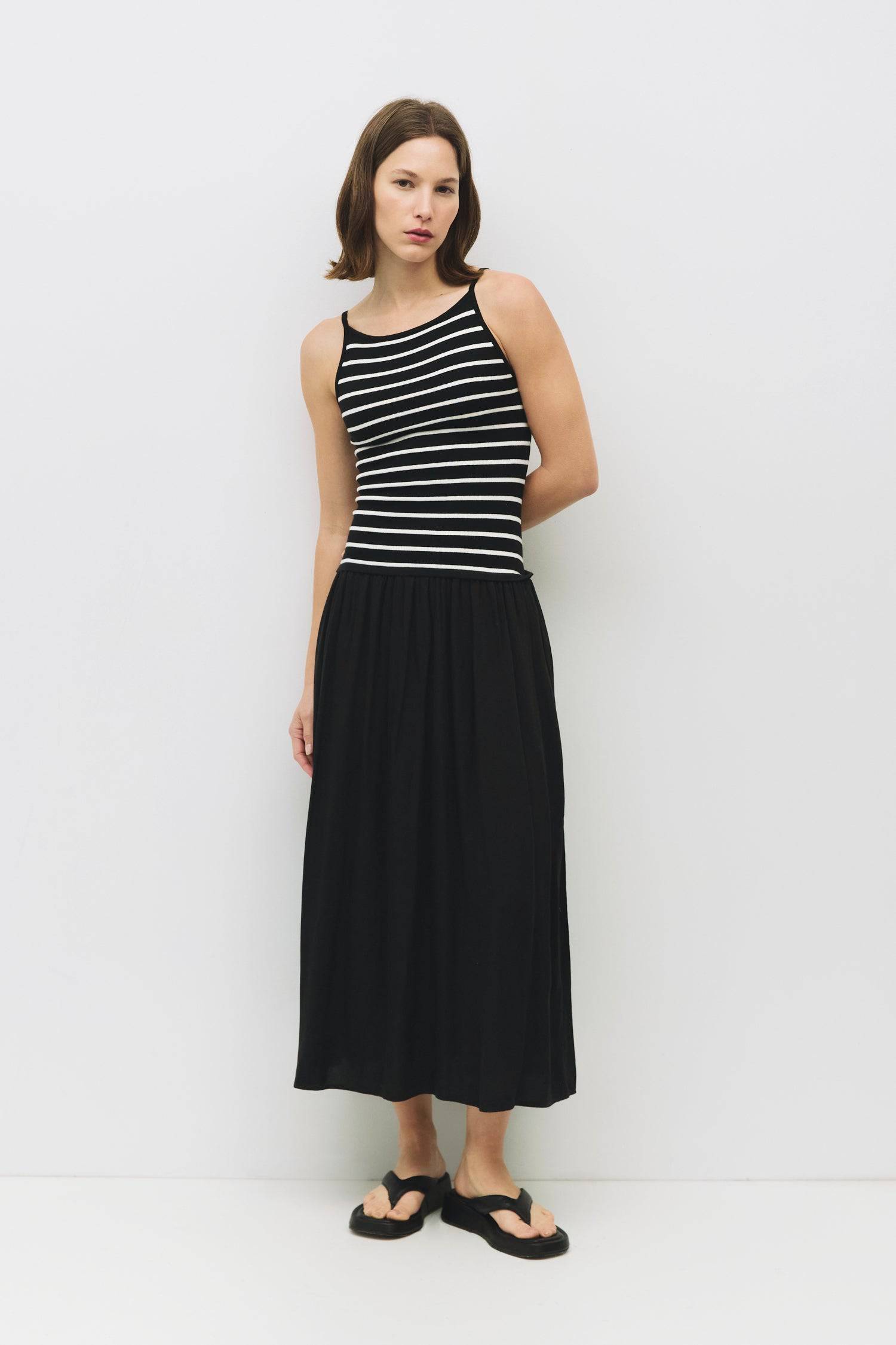 8929244250333, The Indy Dress, Dress, All Row, Black,cf-color-black,cf-color-white,cf-size-l,cf-size-m,cf-size-s,Dress,everyday,fit and flare,Form Fitting,Front Pockets,ivory,Knit,Long Dress,Maxi,maxi dress,Navy,Pocket,Pockets,Relaxed,Relaxed Fit,spring,Square Back,Squared Neckline,Striped,Summer,tank,tank dress,Vertical Stripes, Information The Indy Dress showcases a chic square neckline and a distinctive contrast between its knitted striped bodice and flowing woven skirt. Designed with a flattering maxi l