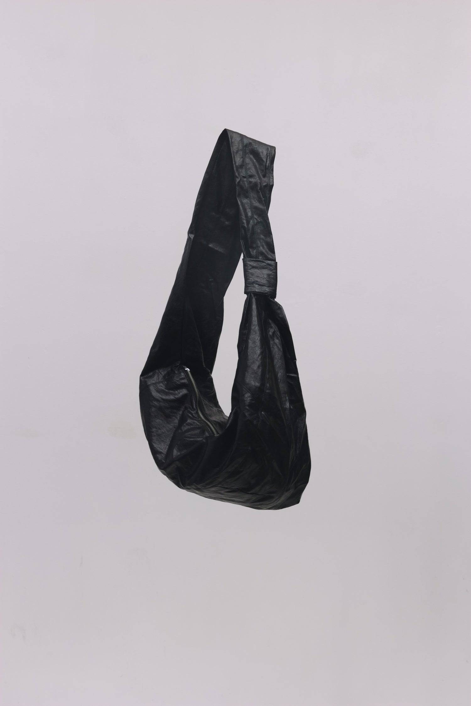 8989192388829, The Charli Bag, Bags, Mod Ref | Common Market, accessories,bag,bags,Black,cf-vendor-mod-ref-common-market,modrefcommonmarket,purse, Information The Charli Bag is a medium-sized crescent sling crafted from glossy distressed leather. It features a sleek curved silhouette, a durable zipper closure, reinforced stitching, and a roomy single compartment. Designed to be worn crossbody or over the shoulder, it’s finished with a matching looped zipper pull and knit detailing along the sides. Details G