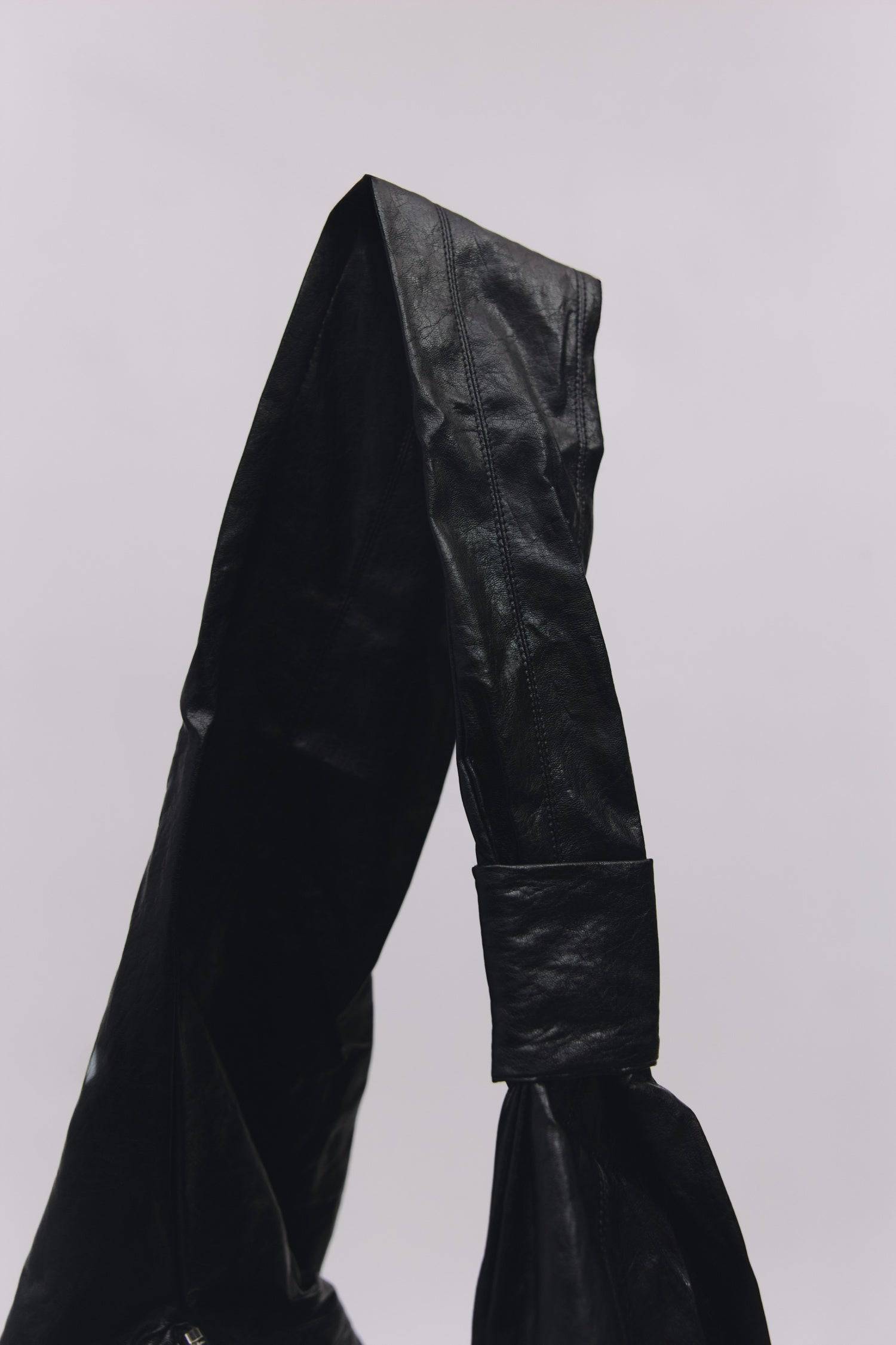 8989192388829, The Charli Bag, Bags, Mod Ref | Common Market, accessories,bag,bags,Black,cf-vendor-mod-ref-common-market,modrefcommonmarket,purse, Information The Charli Bag is a medium-sized crescent sling crafted from glossy distressed leather. It features a sleek curved silhouette, a durable zipper closure, reinforced stitching, and a roomy single compartment. Designed to be worn crossbody or over the shoulder, it’s finished with a matching looped zipper pull and knit detailing along the sides. Details G