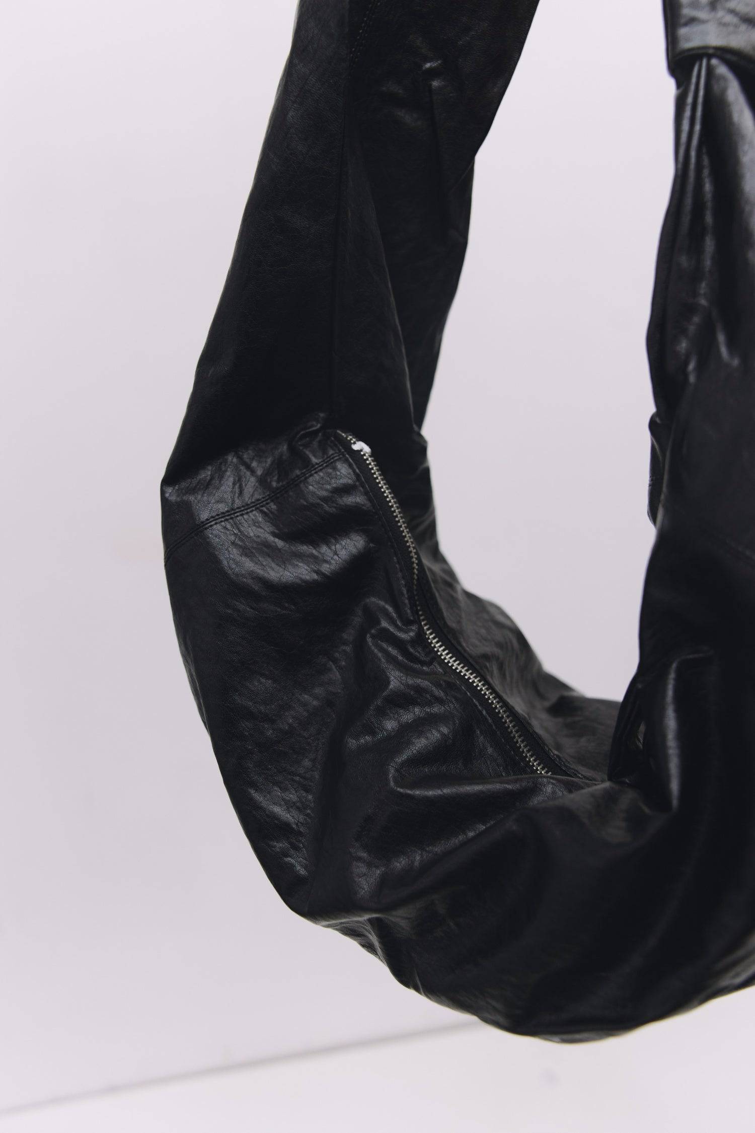 8989192388829, The Charli Bag, Bags, Mod Ref | Common Market, accessories,bag,bags,Black,cf-vendor-mod-ref-common-market,modrefcommonmarket,purse, Information The Charli Bag is a medium-sized crescent sling crafted from glossy distressed leather. It features a sleek curved silhouette, a durable zipper closure, reinforced stitching, and a roomy single compartment. Designed to be worn crossbody or over the shoulder, it’s finished with a matching looped zipper pull and knit detailing along the sides. Details G