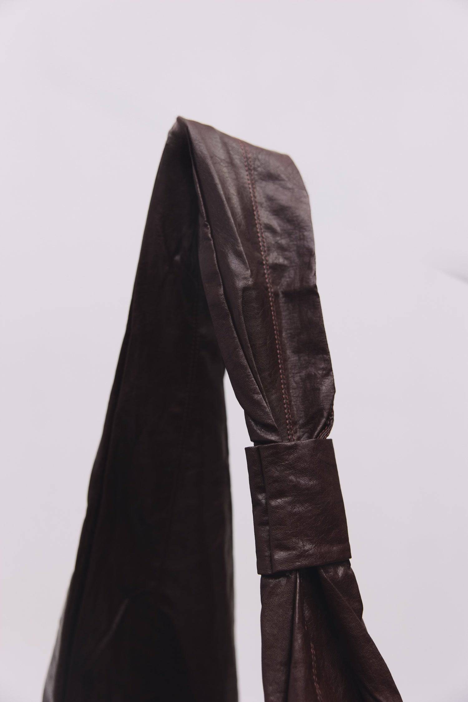 8989192388829, The Charli Bag, Bags, Mod Ref | Common Market, accessories,bag,bags,Black,cf-vendor-mod-ref-common-market,modrefcommonmarket,purse, Information The Charli Bag is a medium-sized crescent sling crafted from glossy distressed leather. It features a sleek curved silhouette, a durable zipper closure, reinforced stitching, and a roomy single compartment. Designed to be worn crossbody or over the shoulder, it’s finished with a matching looped zipper pull and knit detailing along the sides. Details G