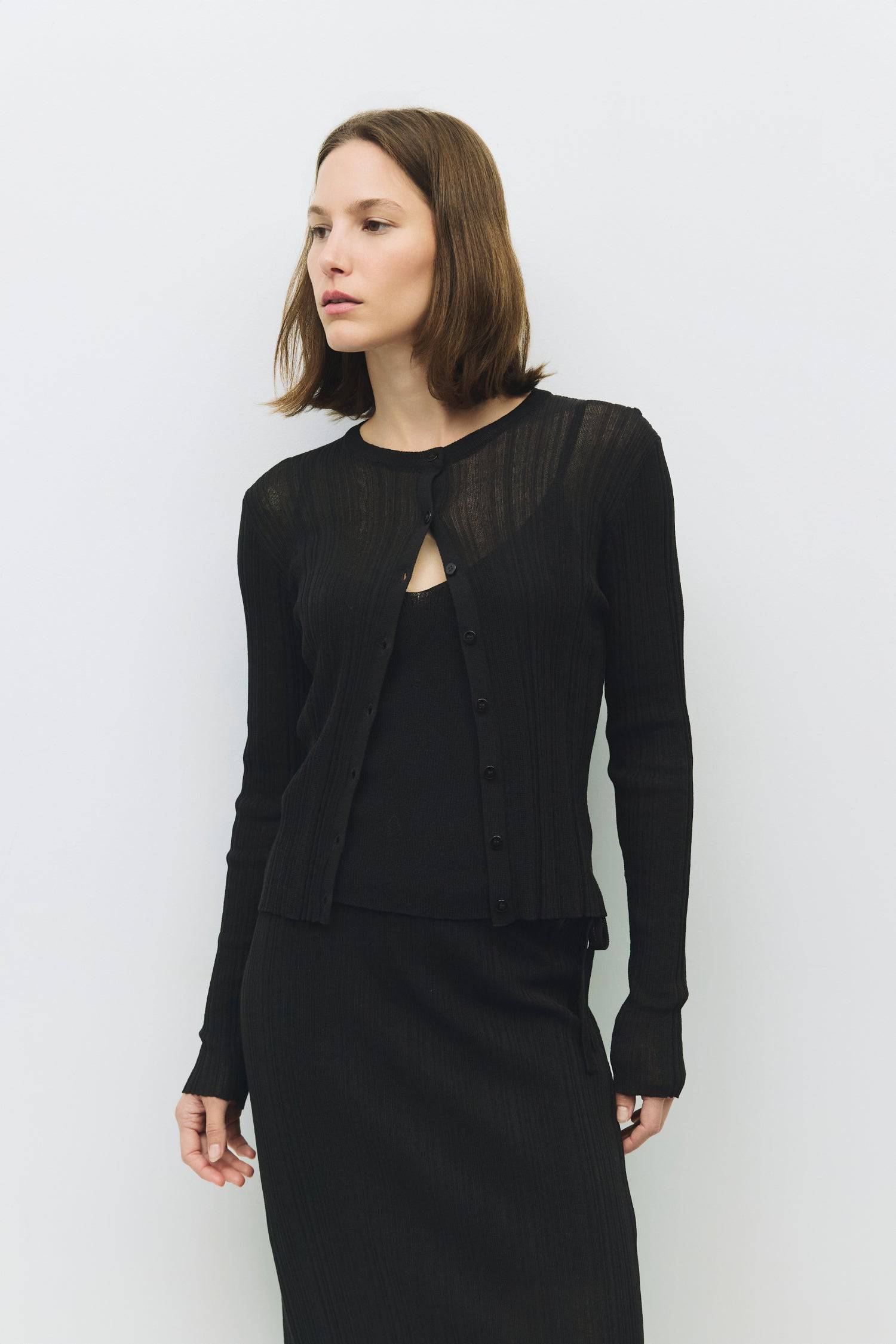 8954055065821, The Trinity Cardigan, Outerwear, Mod Ref, beige,Black,Button up,Cardigan,Casual,cf-color-black,cf-color-cream,cf-size-l,cf-size-m,cf-size-s,cf-size-xl,cf-size-xs,cf-vendor-mod-ref,Cotton,Cream,Knit,Light Blue,Matching Set,Mod Ref,modref,new,Oversized,Pullover,Relaxed,Relaxed Fit,Rib Knit,set,Sets,Soft Knit,tonal,Transitional,Women's, Information The Trinity Cardigan is a duo-style set, featuring a sheer rib-knit cardigan with long sleeves and button-down details, paired with a coordinating ta