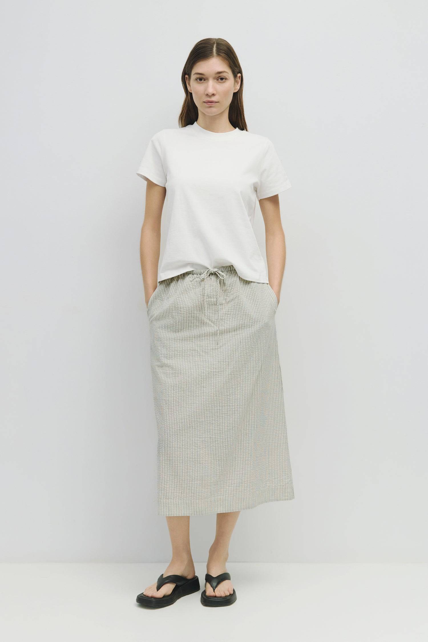 8929228947677, The Genevieve Skirt, Bottoms, Mod Ref, adjustable,Adjustable Cords,Casual,cf-size-l,cf-size-m,cf-size-s,cf-size-xl,cf-size-xs,Comfortable,cotton,Everyday,final-sale,finalsale,Maxi,midi length,Midi Skirt,new,Pinstripes,Pocket,Pockets,Relaxed,Relaxed Fit,sale,seersucker,side pockets,Skirt,Striped,texture,Women's, Information The Genevieve Skirt is a midi-length skirt designed with a lightweight seersucker fabric, featuring an elasticized waistband and front tie for a comfortable fit. With a str