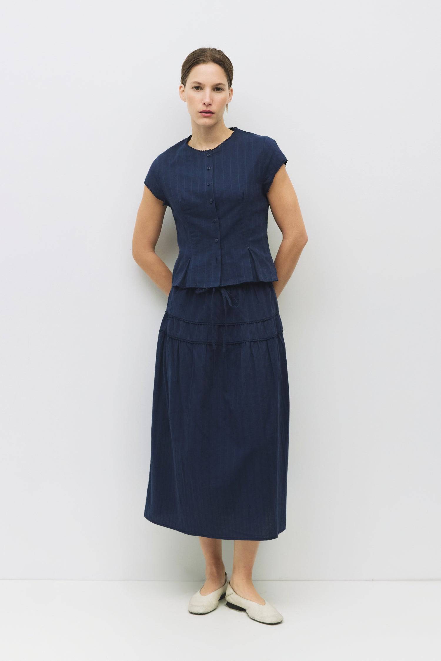 8983694868701, The Keaton Skirt, Bottoms, All Row, Black,Bottom,Bottoms,Casual,cf-color-black,cf-color-cream,cf-size-l,cf-size-m,cf-size-s,cf-vendor-mod-ref,Comfortable,Cotton,Cream,curve skirt,drawstring waist,Dress,Everyday,final-sale,finalsale,Form Fitting,Linen,linen-blend,maxi skirt,Midi Dress,midi length,new,Rib Knit,Ribbed,sale,Sleeveless,Spring,Summer,womens, Information The Keaton Skirt is a midi-length skirt with an elasticized waistband and adjustable ties. Finished with delicate lace trim and a