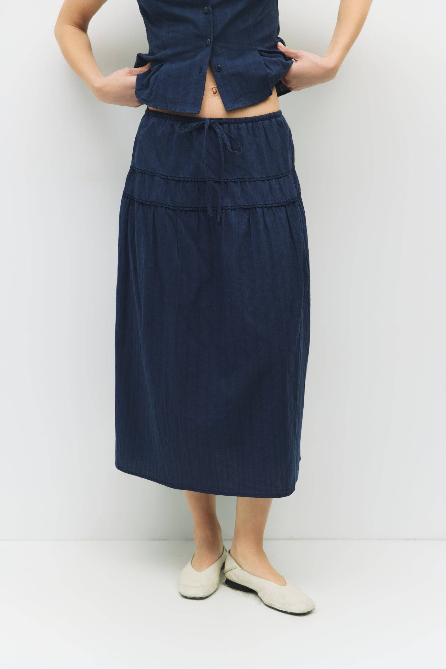 8983694868701, The Keaton Skirt, Bottoms, All Row, Black,Bottom,Bottoms,Casual,cf-color-black,cf-color-cream,cf-size-l,cf-size-m,cf-size-s,cf-vendor-mod-ref,Comfortable,Cotton,Cream,curve skirt,drawstring waist,Dress,Everyday,final-sale,finalsale,Form Fitting,Linen,linen-blend,maxi skirt,Midi Dress,midi length,new,Rib Knit,Ribbed,sale,Sleeveless,Spring,Summer,womens, Information The Keaton Skirt is a midi-length skirt with an elasticized waistband and adjustable ties. Finished with delicate lace trim and a