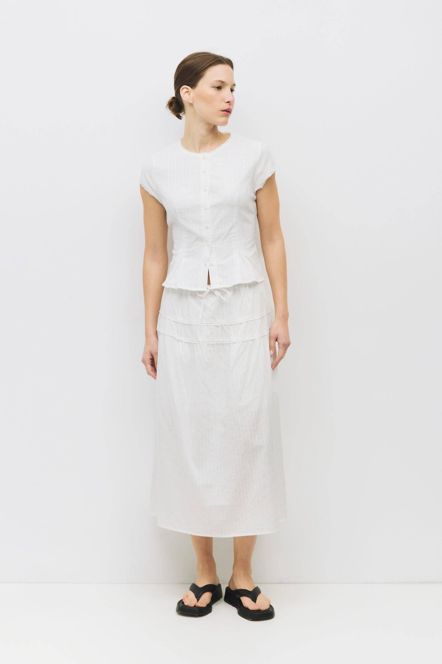 8983694868701, The Keaton Skirt, Bottoms, All Row, Black,Bottom,Bottoms,Casual,cf-color-black,cf-color-cream,cf-size-l,cf-size-m,cf-size-s,cf-vendor-mod-ref,Comfortable,Cotton,Cream,curve skirt,drawstring waist,Dress,Everyday,final-sale,finalsale,Form Fitting,Linen,linen-blend,maxi skirt,Midi Dress,midi length,new,Rib Knit,Ribbed,sale,Sleeveless,Spring,Summer,womens, Information The Keaton Skirt is a midi-length skirt with an elasticized waistband and adjustable ties. Finished with delicate lace trim and a