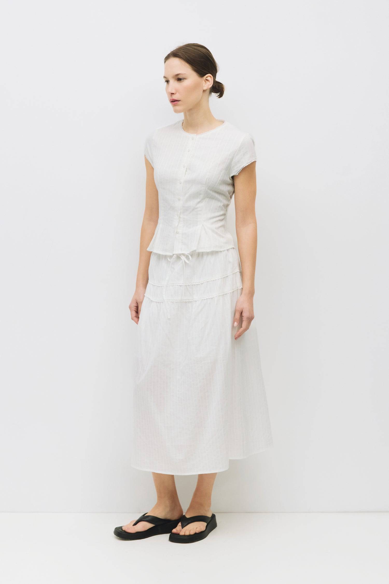 8983694868701, The Keaton Skirt, Bottoms, All Row, Black,Bottom,Bottoms,Casual,cf-color-black,cf-color-cream,cf-size-l,cf-size-m,cf-size-s,cf-vendor-mod-ref,Comfortable,Cotton,Cream,curve skirt,drawstring waist,Dress,Everyday,final-sale,finalsale,Form Fitting,Linen,linen-blend,maxi skirt,Midi Dress,midi length,new,Rib Knit,Ribbed,sale,Sleeveless,Spring,Summer,womens, Information The Keaton Skirt is a midi-length skirt with an elasticized waistband and adjustable ties. Finished with delicate lace trim and a