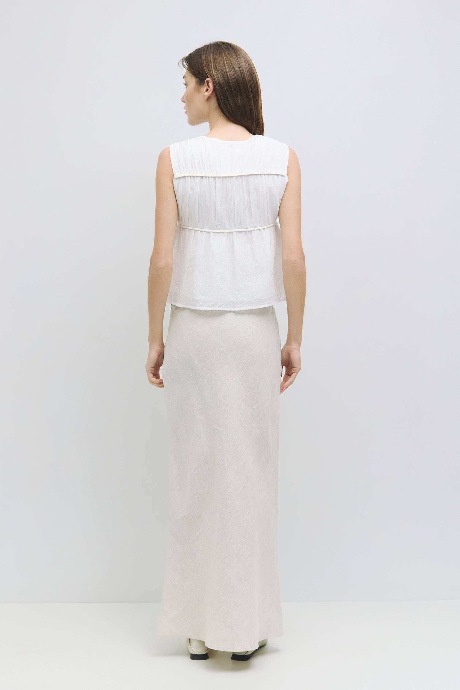 9045682553053, The Cora Top, Tops, Mod Ref, Basic,Basics,Black,boat neck,Casual,cf-color-black,cf-size-l,cf-size-m,cf-size-s,cf-vendor-mod-ref,Comfortable,Everyday,panel,Ribbed Top,Sleeveless,Spring,Summer,Tee,Tops,Transitional,V Neckline,white,Women's,womens top, Information The Cora Top is a sleeveless blouse with paneled shirring that creates a flattering silhouette. Its v-neckline adds a touch of elegance and effortlessly pairs with a midi skirt or high-waisted bottoms. Details 100% Cotton Gathered V Ne