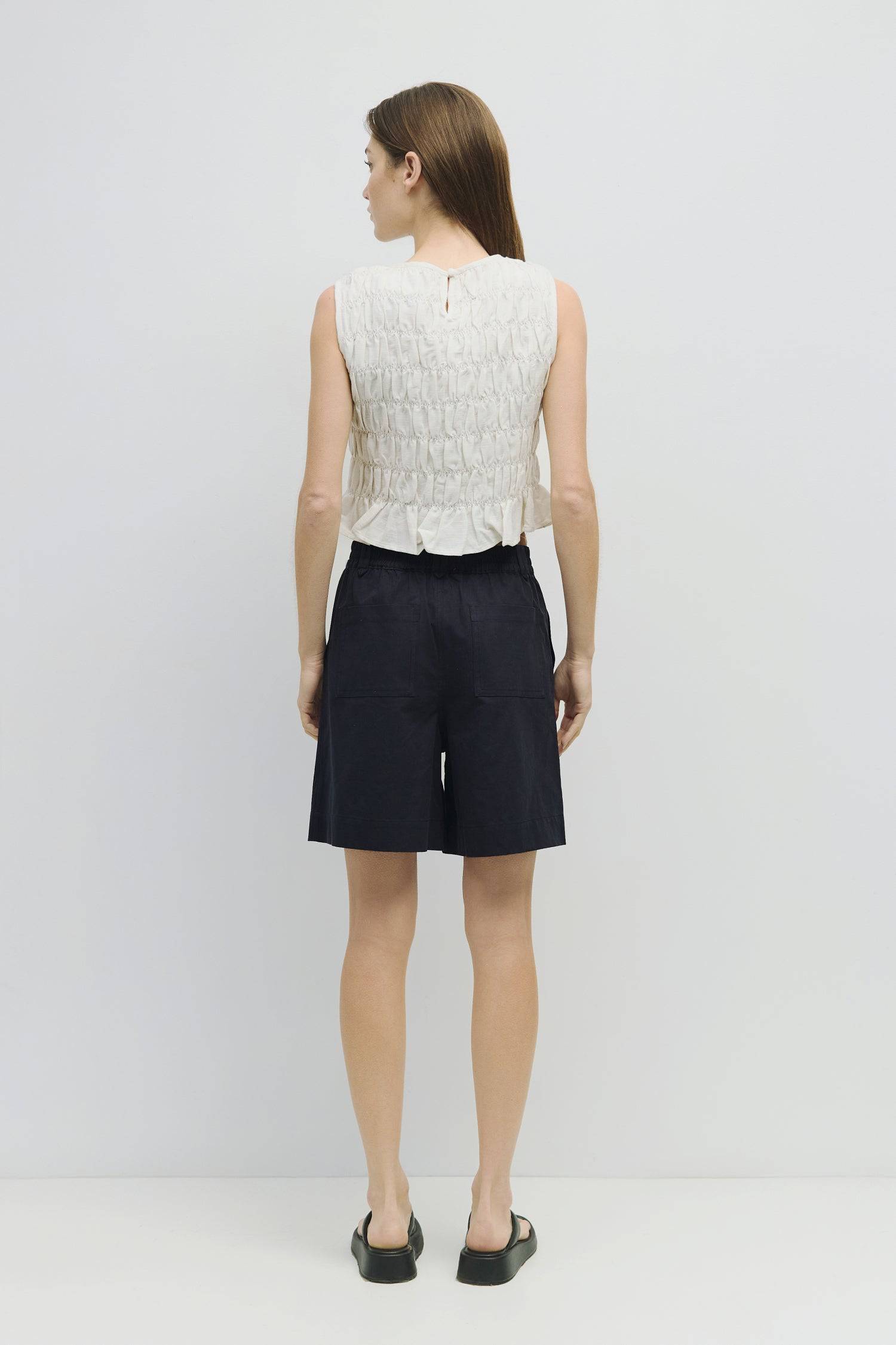 8954058146013, The Florencia Top, Tops, All Row, All Row,allrow,Black,Casual,cf-color-black,cf-color-white,cf-color-yellow,cf-size-l,cf-size-m,cf-size-s,cf-vendor-all-row,cinched,final-sale,finalsale,new,Red,Ruffles,sale,set,Sets,Spring,Summer,texture,white,Women's,womens top, Information The Florencia Top is a sleeveless smocked linen piece with a high neck and a keyhole back with a button closure. Its smocked front and back, plus a playful bottom ruffle, create a relaxed, cropped fit that’s perfect for th