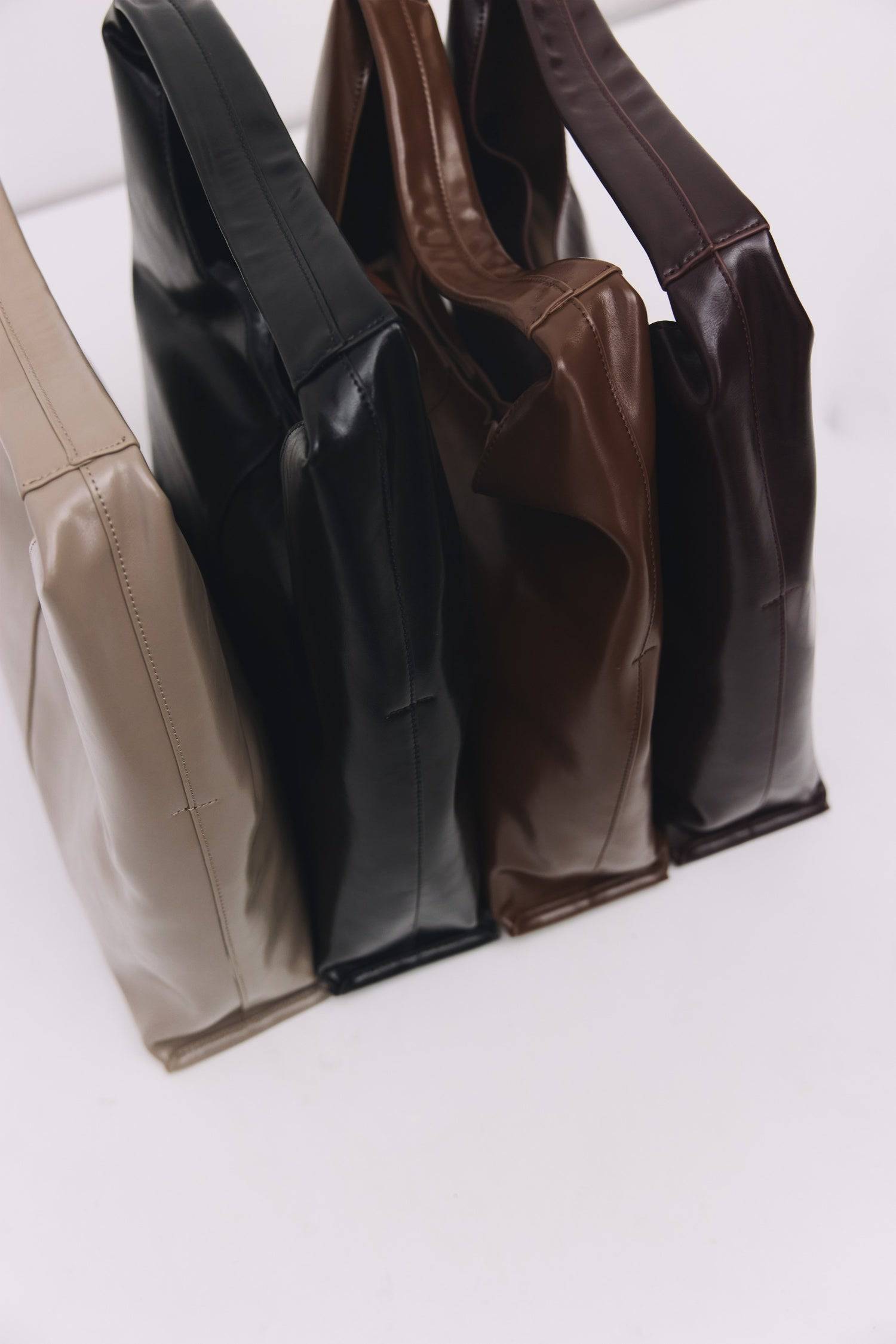 8989083599069, The Cosani Bag, Bags, Mod Ref | Common Market, accessories,bag,bags,cf-color-khaki,cf-color-white,cf-vendor-mod-ref-common-market,dark brown,modrefcommonmarket,Oversized,purse, Information The Cosani Bag is a medium-sized, slouchy patent leather bindle bag with a front seam detail and integrated patent strap. Features a magnetic button closure, flat bottom for structure, and a removable makeup or coin purse for added convenience. Details 100% Cowhide Slouchy Shape Magnetic Button Closure Remo