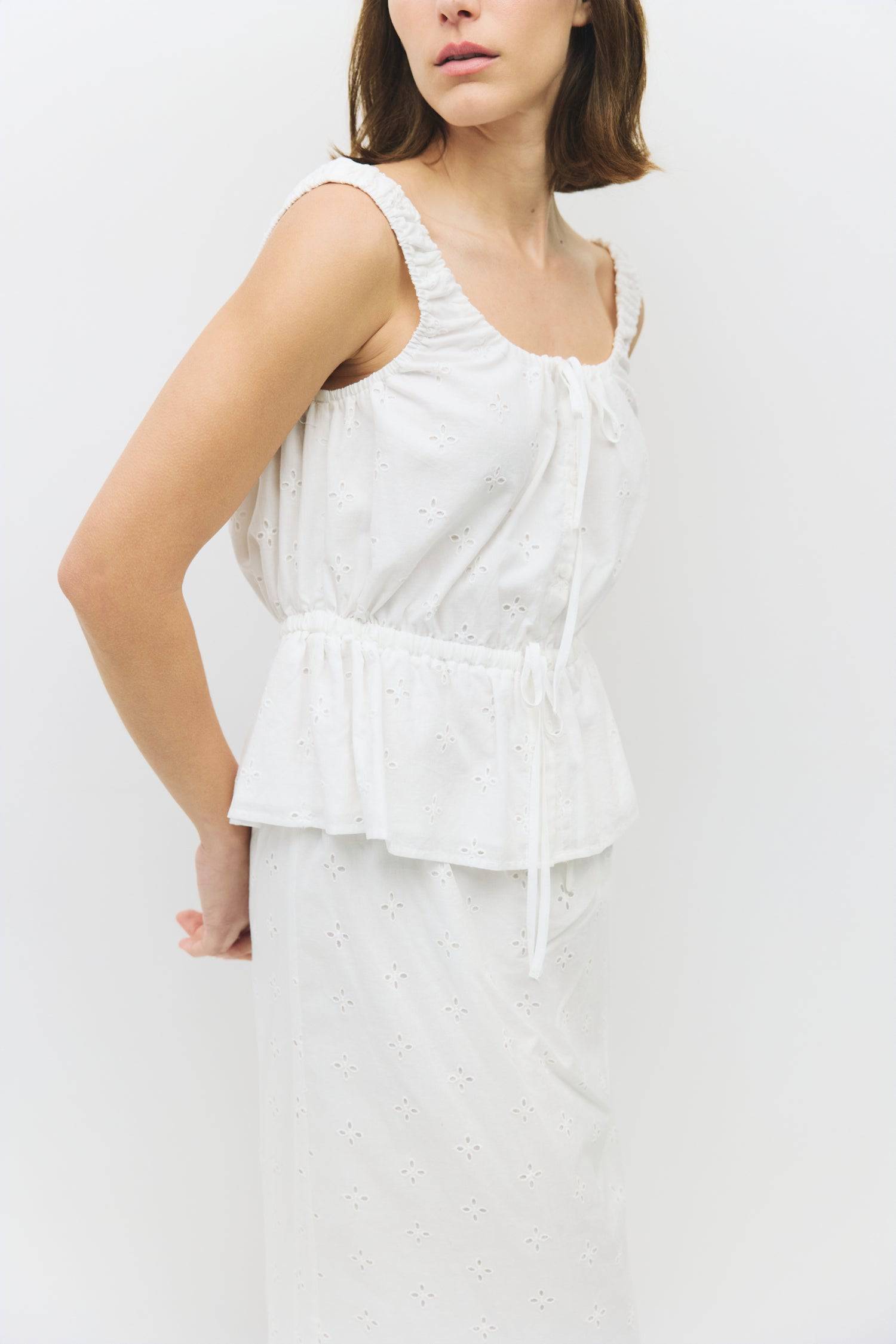 8983733043421, The Kristina Top, Tops, All Row, 90s,Basic,Basics,Black,Blue,Casual,cf-color-black,cf-color-blue,cf-color-white,cf-size-l,cf-size-m,cf-size-s,cf-vendor-mod-ref,Comfortable,Crew Neck,Crew Neckline,Everyday,Form Fitting,Ribbed,Ribbed Fabric,Ribbed Top,Short Sleeve,Spring,stretch,Stretchy,Summer,Tee,Tops,Transitional,white,Women's, Information The Kristina Top is a sleeveless cotton eyelet piece featuring a gathered neckline and adjustable ties for a custom fit. With an elasticized waist and ful