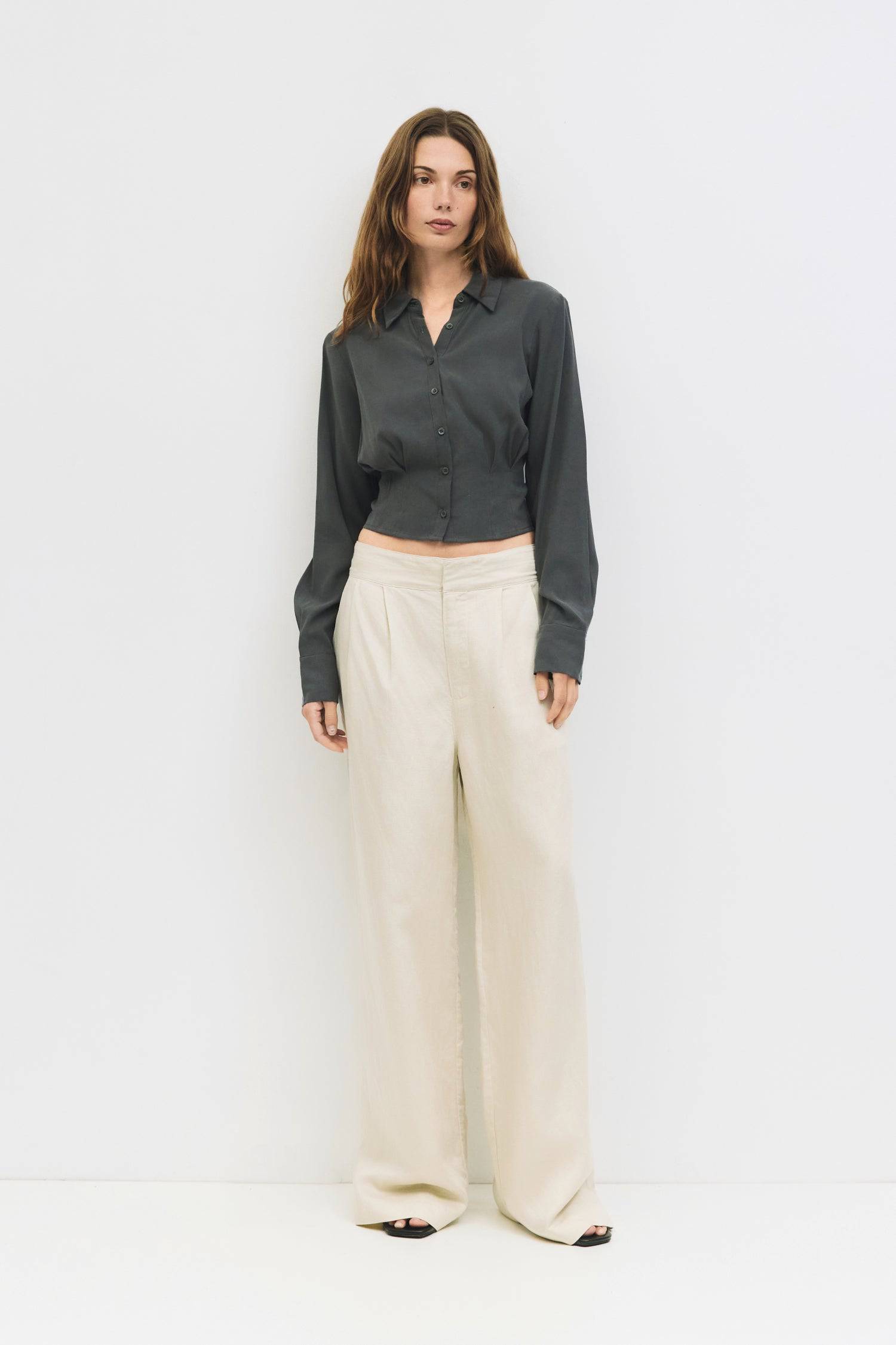 9084452274397, The Violeta Top, Tops, Mod Ref, Blouse,Breathable,Button down,Button Down Shirt,Button Up,Casual,cf-color-grey,cf-color-white,cf-size-l,cf-size-m,cf-size-s,cf-vendor-mod-ref,cinched,Cinched Back,Cinched Waist,collared,Collared Top,Cropped,cropped hemline,everyday,Grey,Long Sleeve,Long Sleeve Top,new,Pleated,Silk,Silky,slim fit,spring,Tapered,Tops,white,womens,Work,Workwear, Information The Violeta Top is a slim-fit button-down blouse with a collared neckline and long sleeves. It features a ta