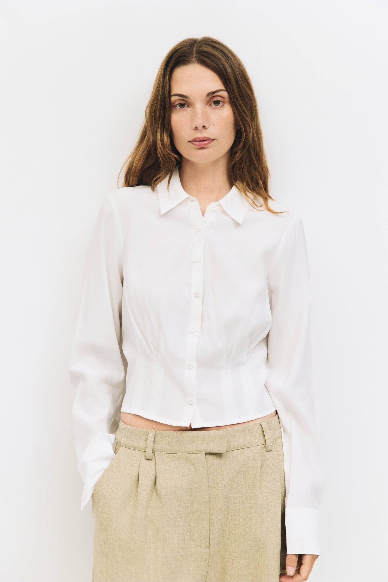 9084452274397, The Violeta Top, Tops, Mod Ref, Blouse,Breathable,Button down,Button Down Shirt,Button Up,Casual,cf-color-grey,cf-color-white,cf-size-l,cf-size-m,cf-size-s,cf-vendor-mod-ref,cinched,Cinched Back,Cinched Waist,collared,Collared Top,Cropped,cropped hemline,everyday,Grey,Long Sleeve,Long Sleeve Top,new,Pleated,Silk,Silky,slim fit,spring,Tapered,Tops,white,womens,Work,Workwear, Information The Violeta Top is a slim-fit button-down blouse with a collared neckline and long sleeves. It features a ta