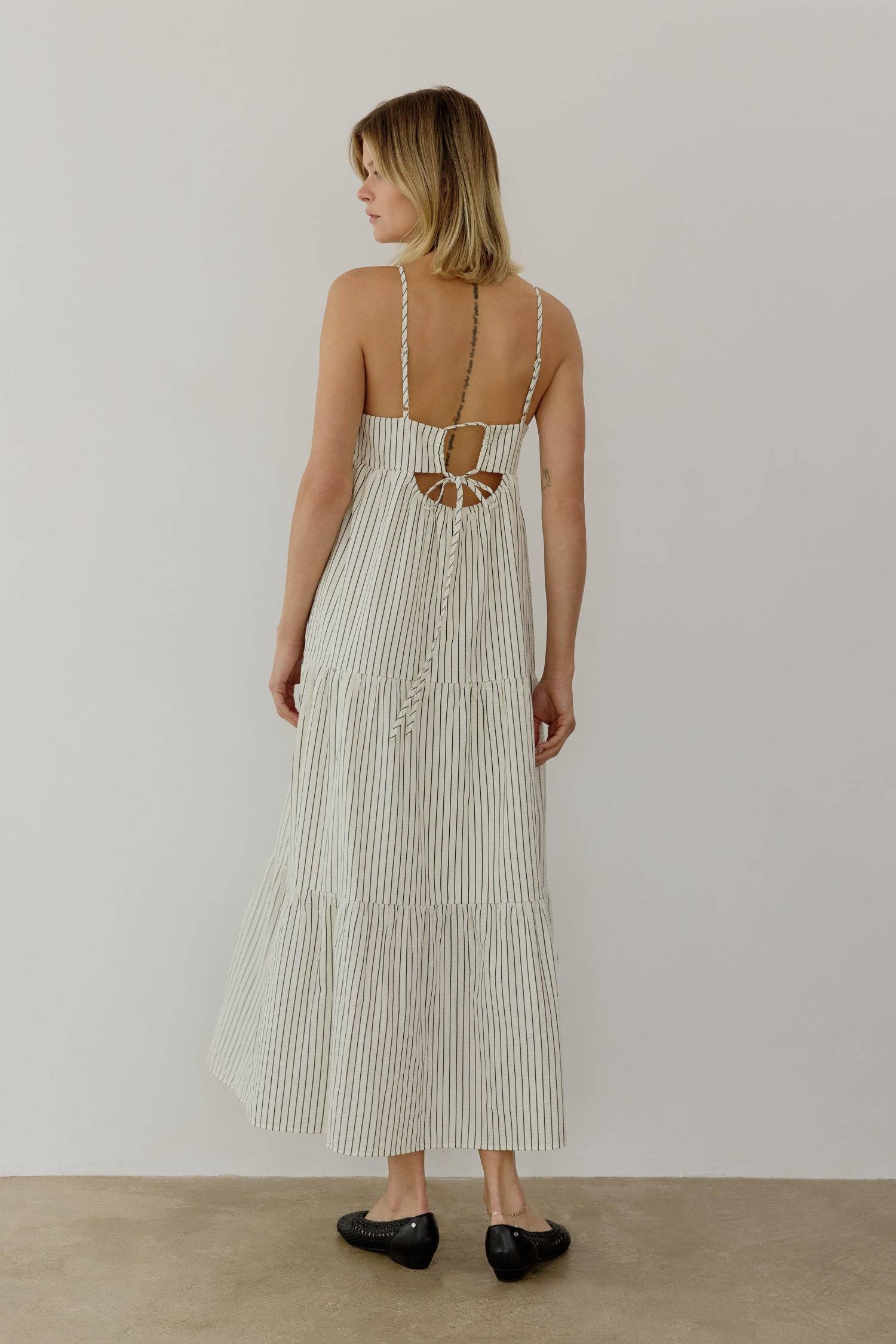 8668654895325, The Aspen Dress, Dress, All Row, adjustable straps,Casual,cf-color-cream,cf-size-l,cf-vendor-all-row,Comfort,Comfortable,Cream,Dress,Feminine,full skirt,Midi,Midi Dress,midi length,new,open back,Pinstripes,Pockets,Semi-Formal,Sleeveless,Sleeveless Dress,Spring,Stripe,Striped,Stripes,Summer,Tiered Dress,versatile,Warm,warm weather,Womens, Information The Aspen Dress is a striped seersucker tiered midi dress that features a square neckline, adjustable shoulder straps, and a back tie detail for 